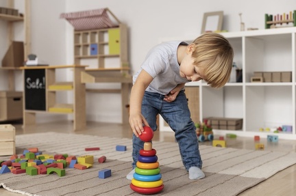 full-shot-kid-playing-floor-with-wooden-toy