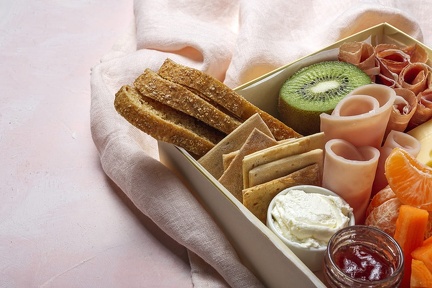 healthy-brunch-box-take-away-with-ham-strawberries-kiwi-bread-cookies-cheese-carrots-tangerines-hummus (1)
