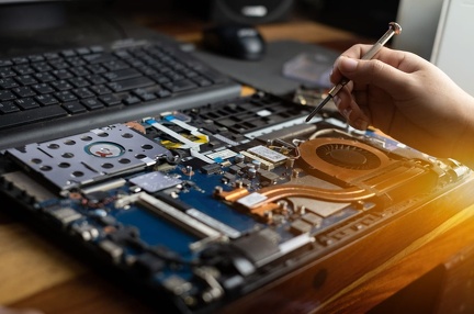 technician-repairing-broken-laptop-notebook-computer-with-screwdriver
