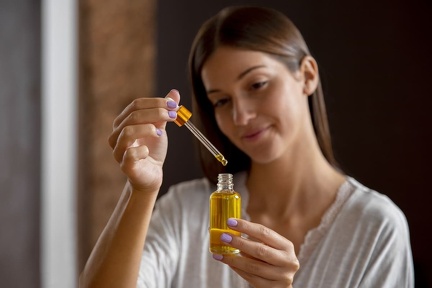 medium-shot-woman-holding-serum-bottle (1)